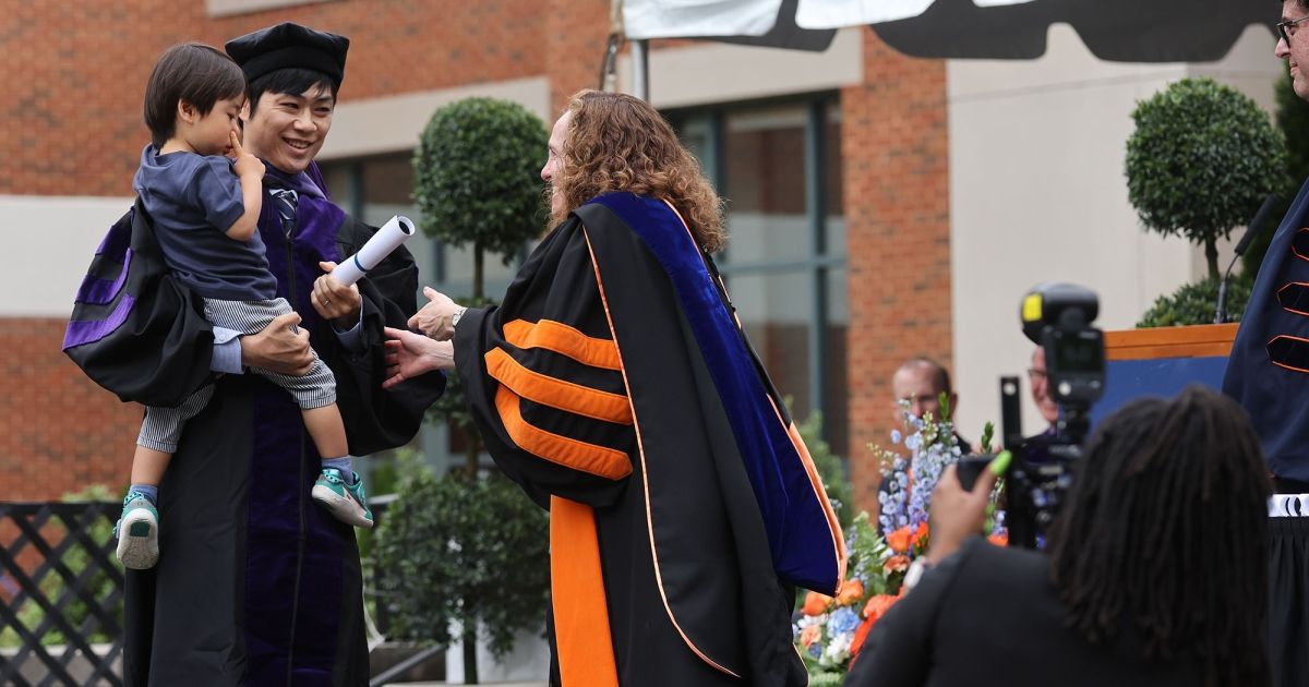 Dean Risa Goluboff greets a graduate and his son.