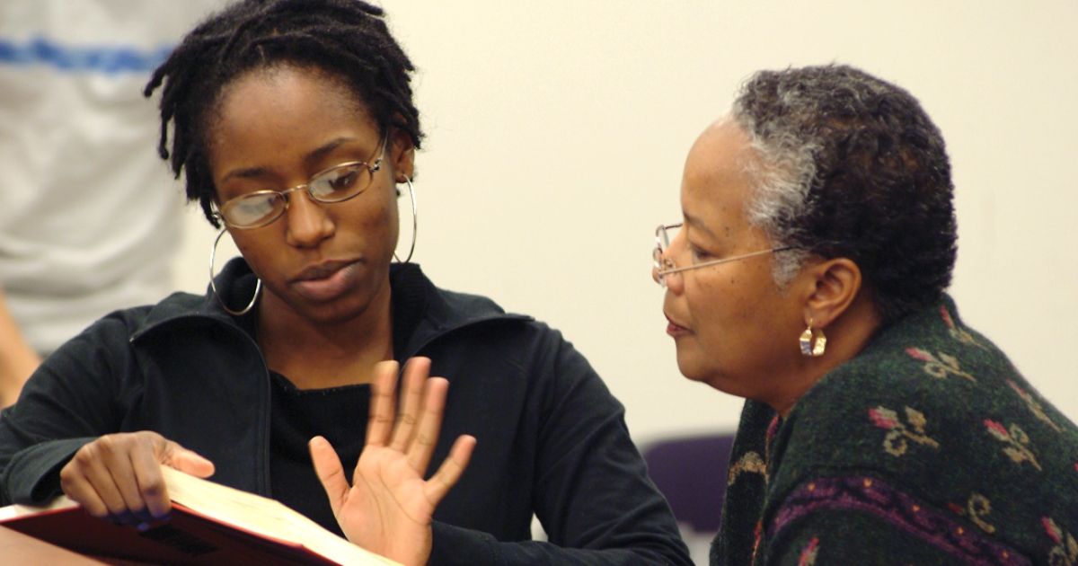 Professor Mildred Robinson talks with Gigi Parris ’06  after class. 