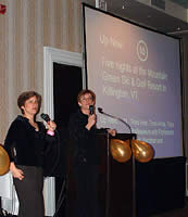 Professors Liz Magill (left) and Anne Coughlin help auction a vacation to a ski and golf 